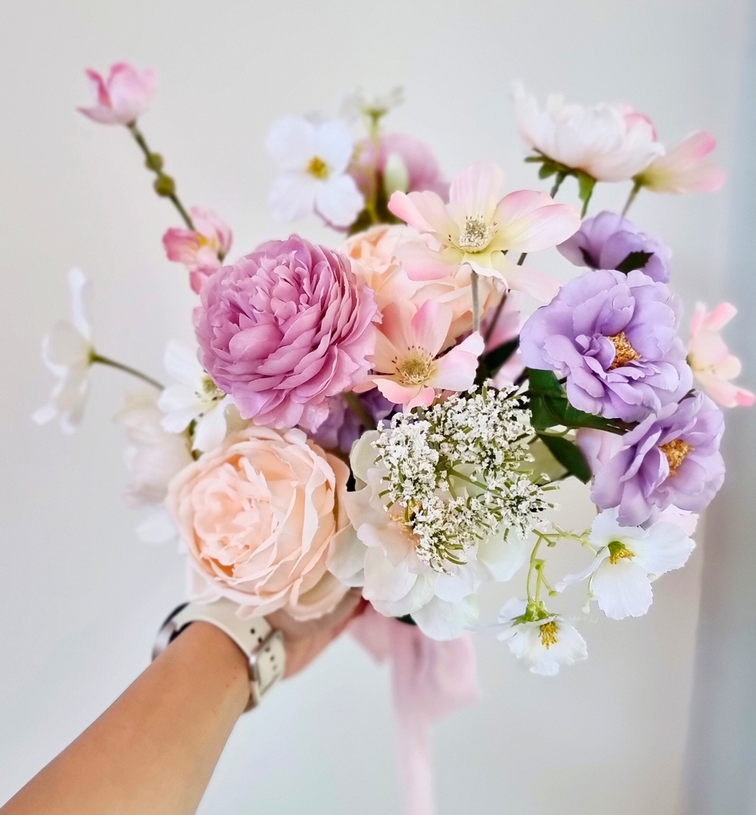 Heather flowers bouquet in pink vase on white table